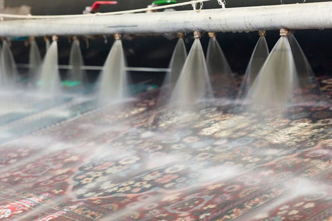 Rückstandsfreies Spülen des Teppichs nach der Teppichwäsche mit klarem Wasser